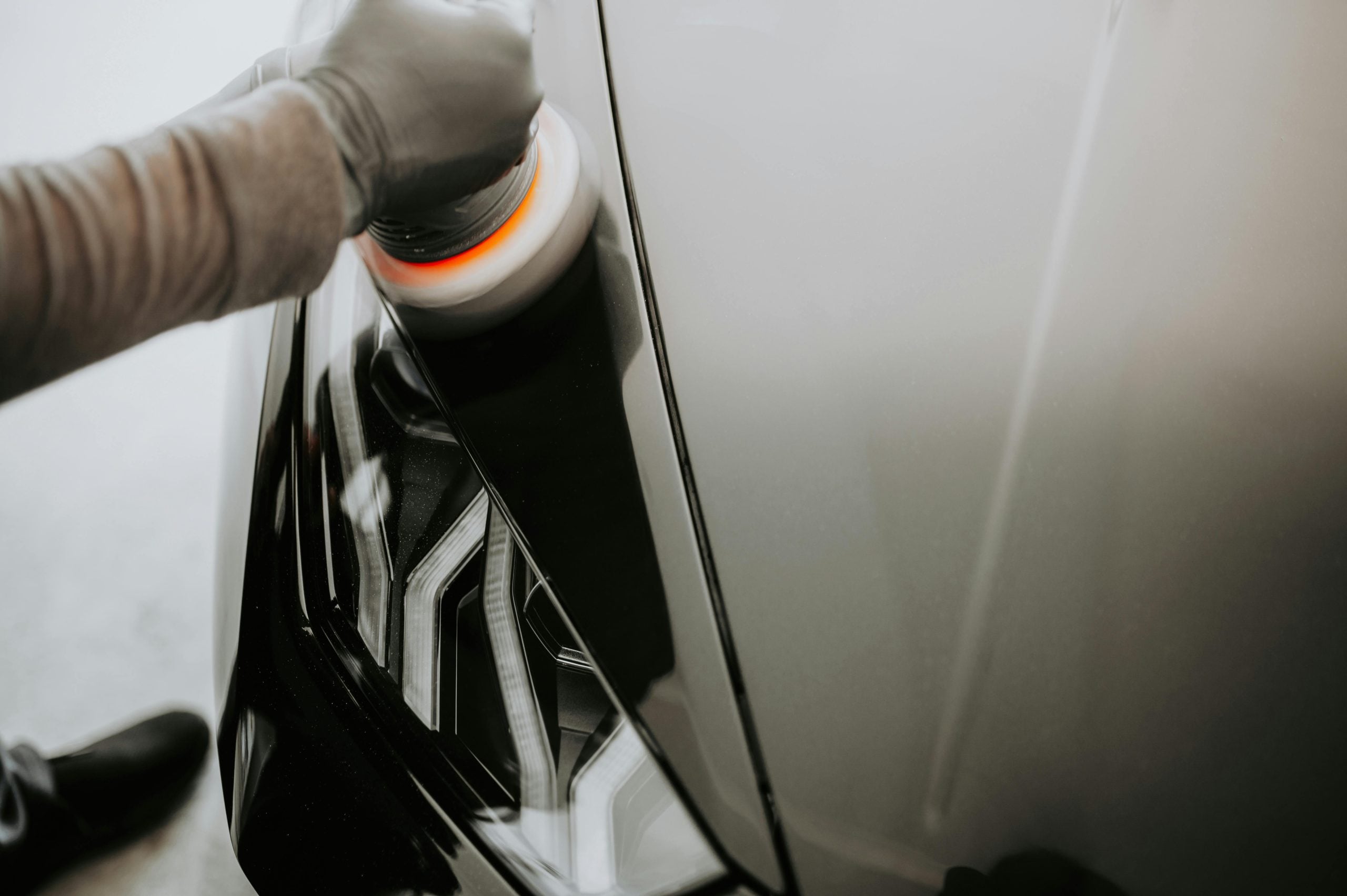 Technician using orbital polisher on a car panel at Spot On Panel Beaters
